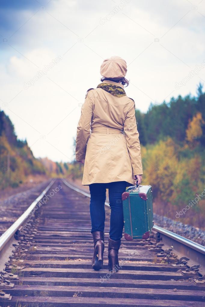 Elegant woman with a suitcase traveling by rail.