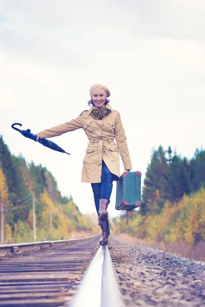 Elegante vrouw met een koffer reizen per spoor. — Stockfoto