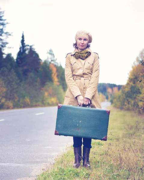 Mujer elegante con una maleta que viaja por la carretera . —  Fotos de Stock