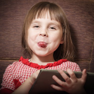 Küçük kız bir modern dijital tablet ile oynamak.