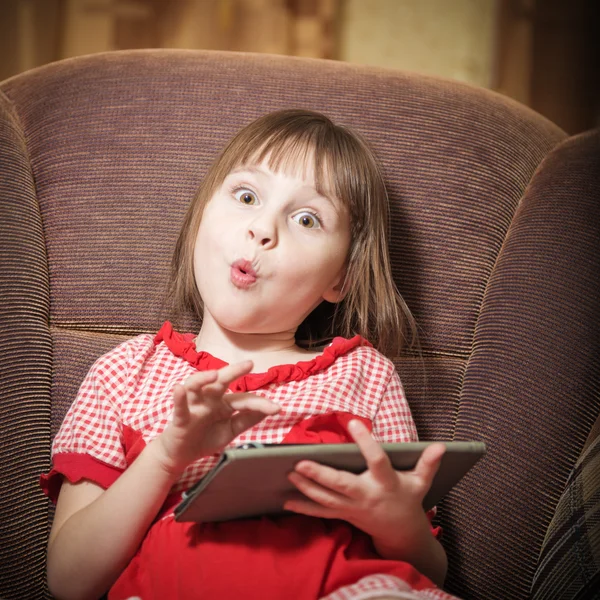 Liten flicka leker med en modern digital tablet. — Stockfoto