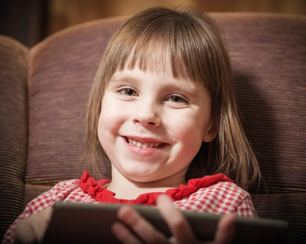 Liten flicka leker med en modern digital tablet. — Stockfoto