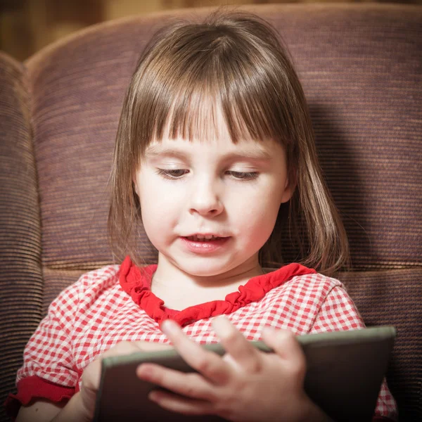 Niña jugando con una tableta digital moderna . —  Fotos de Stock