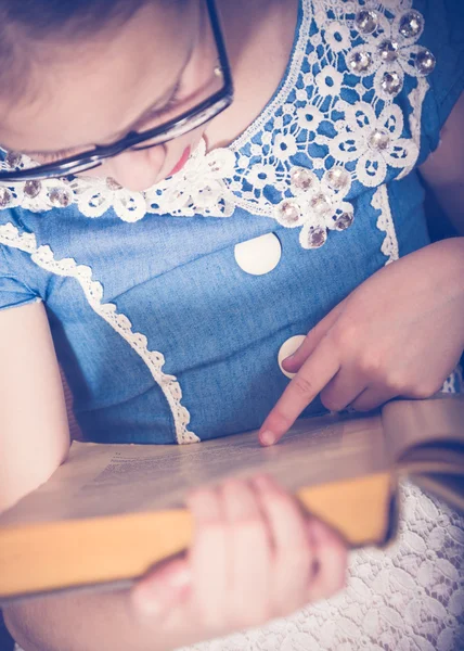 Ragazza che legge un libro a casa seduta su una poltrona . — Foto Stock