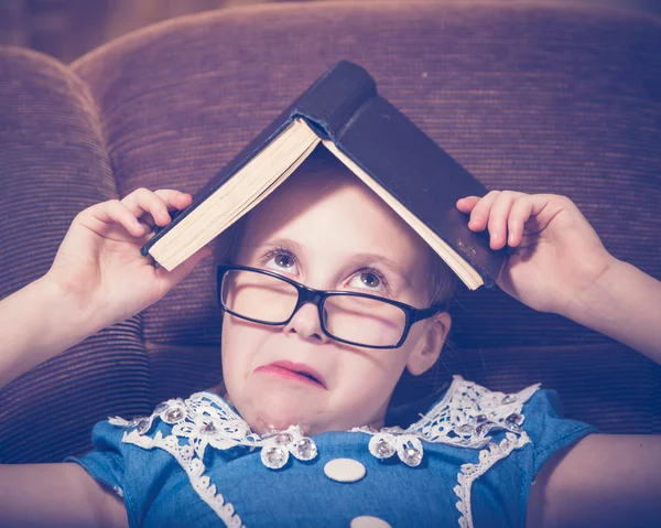 Menina lendo um livro em casa sentado em uma poltrona . — Fotografia de Stock