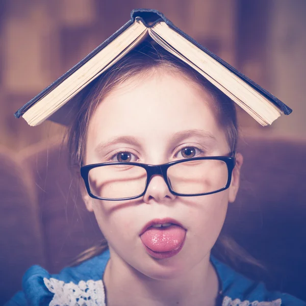 Meisje het lezen van een boek thuis zitten in een leunstoel. — Stockfoto