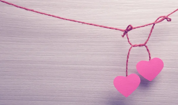 Dos corazones de papel colgando de una cuerda . — Foto de Stock