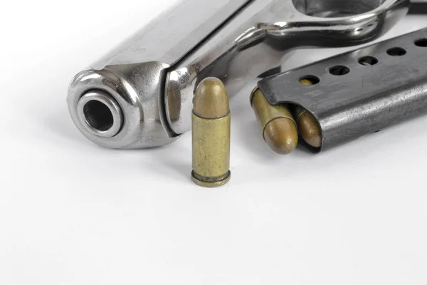 Pistool en munitie op de witte achtergrond — Stockfoto
