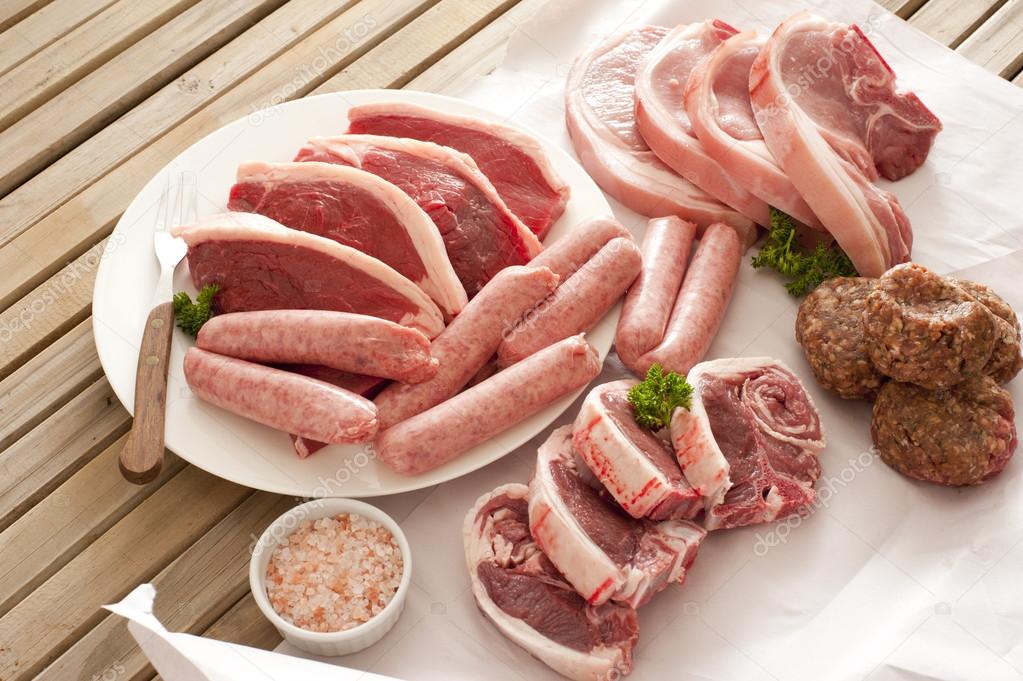 Large assortment of raw meat on a table