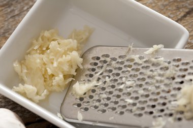 Grated fresh garlic with a grater clipart