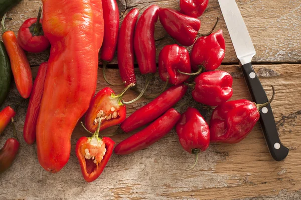 Litet sortiment av red hot peppers nära kniv — Stockfoto