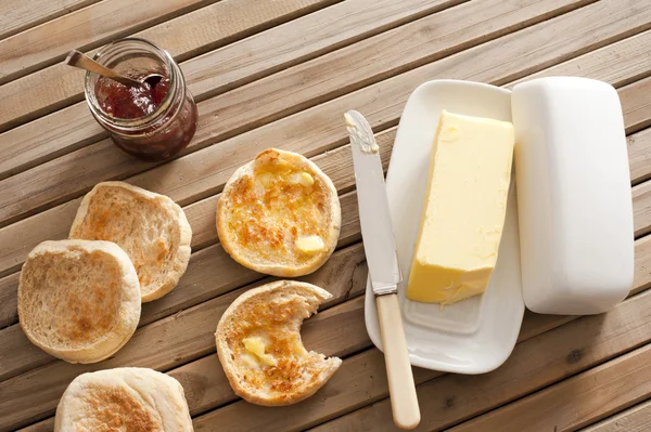 Muffins ingleses, manteiga e compota na mesa de madeira — Fotografia de Stock