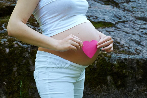 Těhotná žena s růžové srdce — Stock fotografie