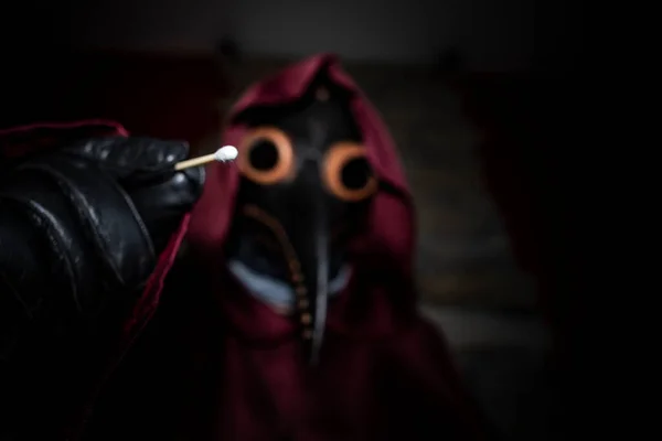 a doctor in a plague mask takes a test for coronavirus