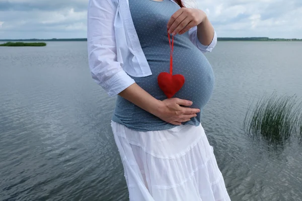 Mujer embarazada con corazón — Foto de Stock