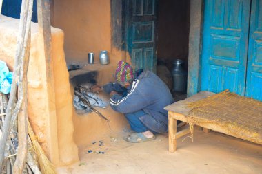 Manaslu / Nepal - 01.04.2014: Nepal köyünde bir adam yemek pişirmek için ateş yakıyor