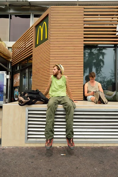 Personas sentadas cerca del restaurante McDonald 's . — Foto de Stock