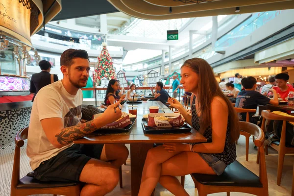 Customers eat food at food court