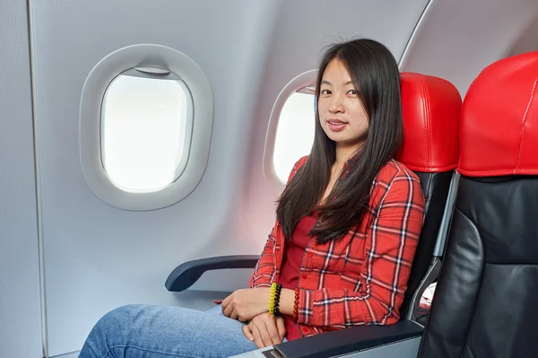 Frau sitzt in Stuhl im Flugzeug — Stockfoto