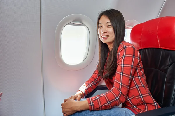 Frau sitzt in Stuhl im Flugzeug — Stockfoto