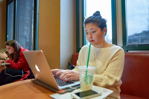 Женщина в кафе Starbucks — стоковое фото