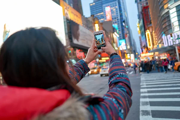 Mujer tomando fotos en Nueva York por la noche . — Foto de Stock