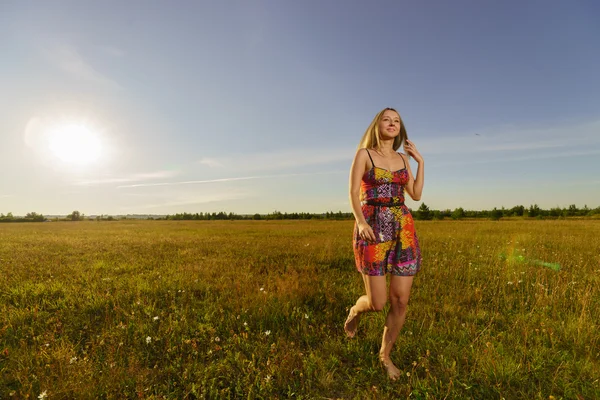 Young woman walks in field — Stock Photo, Image