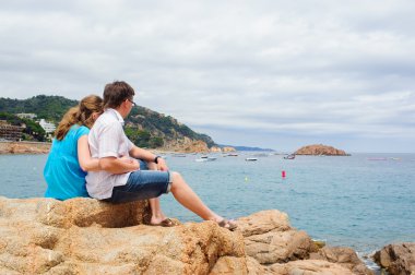 genç bir çift deniz kenarında oturup