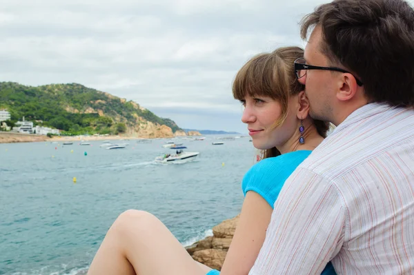 Young couple sit near the sea — Stock Photo, Image