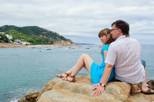 Young couple sit near the sea — Stock Photo, Image
