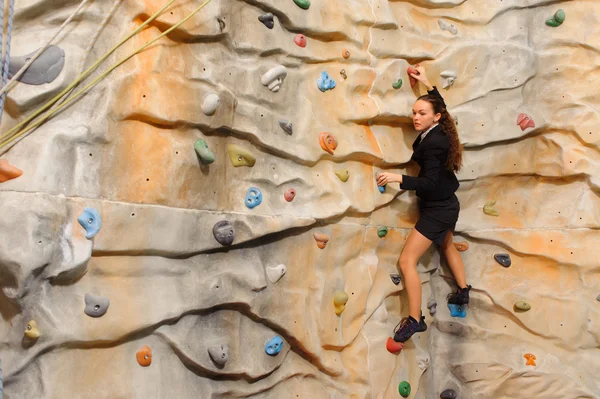 Affärskvinna klättring på konstgjorda klippa — Stockfoto