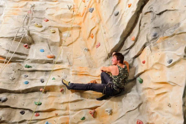 Man climbing on man-made cliff — Stock Photo, Image