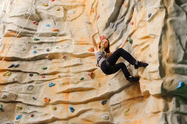 Femme grimpant sur une falaise artificielle — Photo