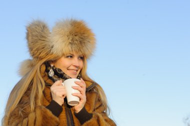 Kahve fincanı olan genç bir kadın.