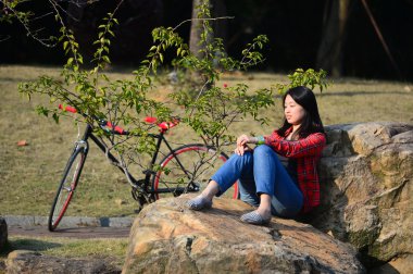 Çinli kadın taş üzerine oturan