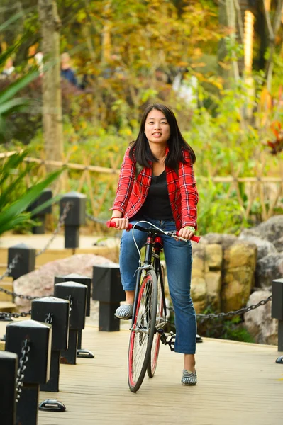 中国女人在公园骑自行车 — 图库照片