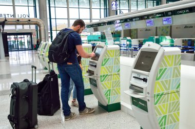 man use self check-in kiosk