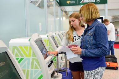 women use self check-in kiosks