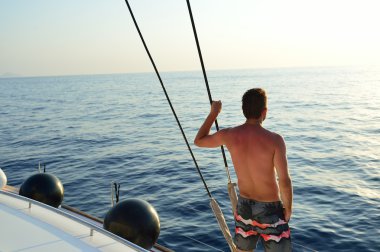 Santorini deniz kenarında yatta adam