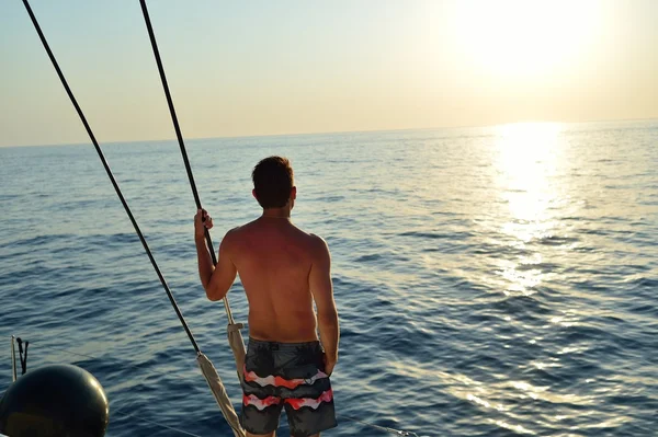 Człowiek na jacht w pobliżu morza Santorini — Zdjęcie stockowe