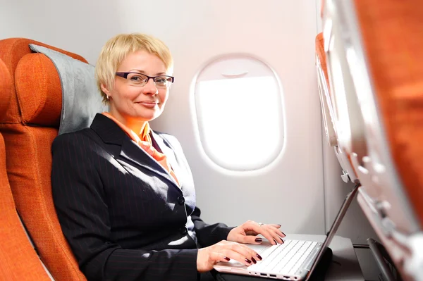 Femme d'affaires posant dans un avion à réaction — Photo