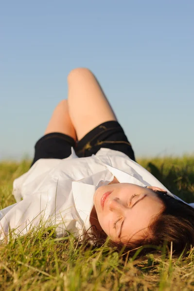 Frau liegt auf dem grünen Gras — Stockfoto