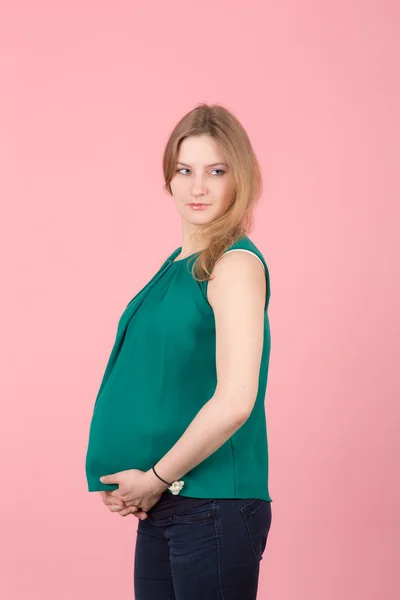 Gravid kvinna på en rosa bakgrund — Stockfoto