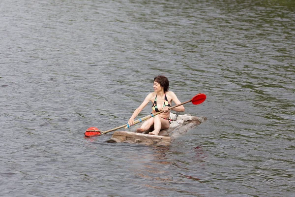 Mujer flotando en una balsa de madera — Foto de Stock