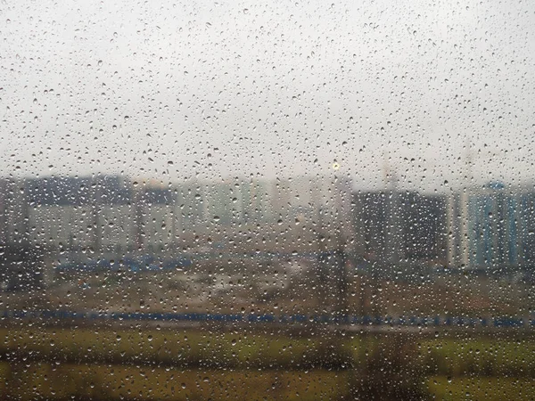 the city outside the window with raindrops on a cloudy day