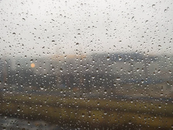 the city outside the window with raindrops on a cloudy day