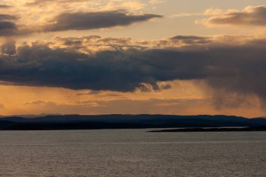 Gün batımında denizin üzerindeki bulutlarla dramatik manzara