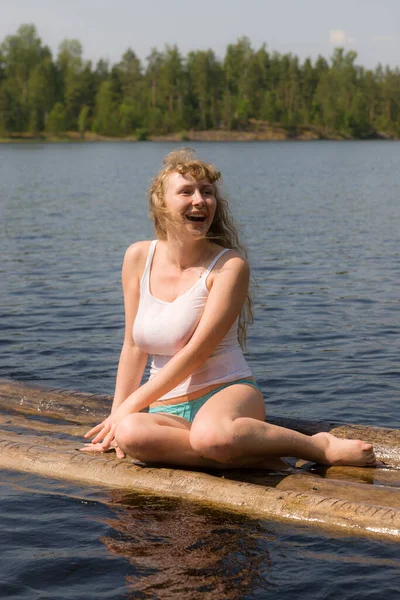 夏の湖の上の木製の筏の上の女の子 — ストック写真