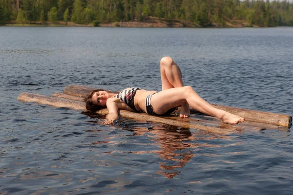 夏の湖でいかだに乗ってビキニを着た女の子 — ストック写真