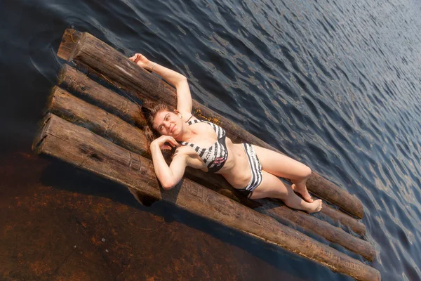 夏の湖のいかだに乗ってビキニ姿の女の子が — ストック写真
